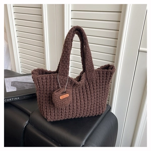 Detalle de bolso tote marrón de punto hecho a mano con colgante de corazón y etiqueta