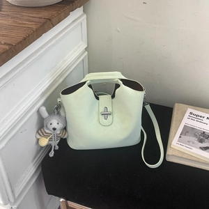 Détail du sac seau en cuir vert menthe avec fermoir rotatif argenté et pendentif lapin