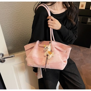 Pink woven tote bag featuring a leather shoulder strap and a cute horse bag charm
