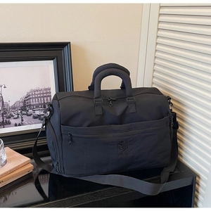 Close-up of black travel bag with reinforced handles and NINGJIA embossed logo detail