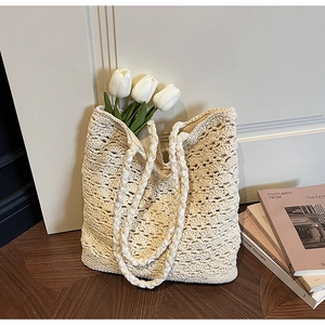 Close-up of cream crochet tote bag featuring intricate openwork knitting and dual straps