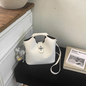 Détail du sac seau blanc avec fermoir rotatif argenté et charm de souris grise