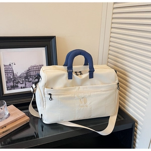 Close-up of stylish off-white travel bag with durable handles and adjustable shoulder strap