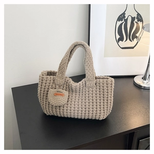 Detalle de bolso cubo de ganchillo hecho a mano con etiqueta de cuero y textura tejida