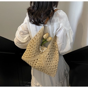 Détail du sac hobo en paille tressée avec chaîne de perles et bandoulière en cuir