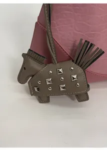 Detail of grey leather horse charm with silver studs on pink pebbled handbag