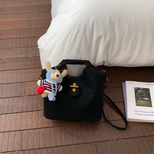 Détail d'un sac seau vintage noir avec fermoir doré et un charmant lapin décoratif