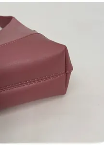 Detail view showing wide bottom base and double stitching on dusty pink shoulder bag