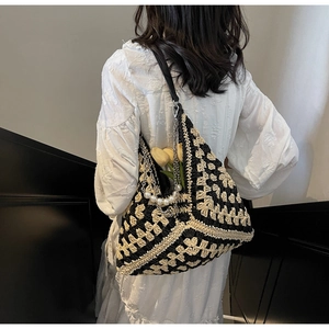 Détail du sac cabas tissé avec chaîne en perles et texture crochetée géométrique