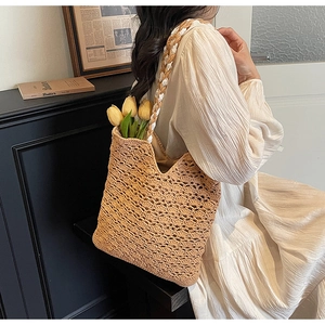 Close-up of the hollow-out woven texture and sturdy shoulder strap of the straw tote bag