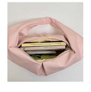 Top view of pink dumpling bag interior showing capacity for books, phone, and umbrella
