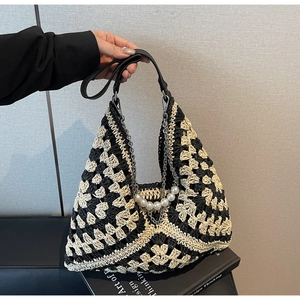 Détail du sac crocheté avec bandoulière en perles et poignée en cuir noir