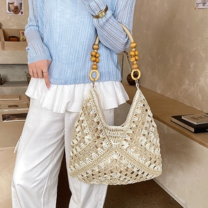 Dettaglio della borsa tote all'uncinetto beige con motivo a onde e manico in legno