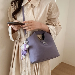 Détail du sac seau violet en similicuir avec fermoir cabillot argenté et charm ours tricoté