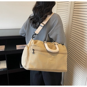 Detail showing detachable shoulder strap and side zipper compartment of travel bag