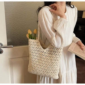 Detail of hand-woven hollow knit tote bag with soft texture and wave pattern in beige