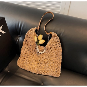 Détail du sac cabas en paille tissée avec bandoulière en cuir et chaîne perlée