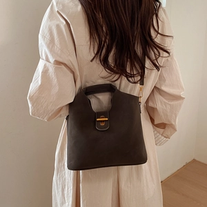 Détail d'un sac seau vintage avec fermoir en métal doré et texture mate élégante