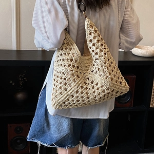 Dettaglio della borsa tote all'uncinetto beige con maglia traforata e anelli tondi