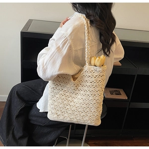 Detail of crochet tote bag showing woven shell patterns and large capacity with tulips