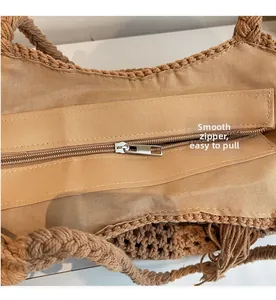 Close-up of the smooth metal zipper and khaki fabric lining on the woven straw beach bag