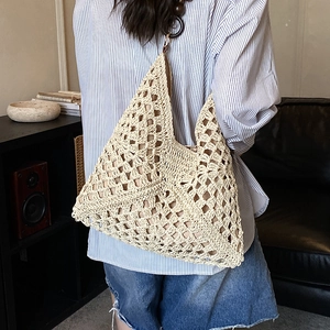 Dettaglio della borsa tote intrecciata a mano con perle in legno e trama all'uncinetto