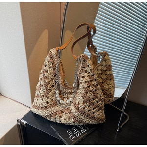 Détail du sac cabas en paille crocheté avec chaîne argentée et perles artificielles