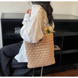 Detail of hollow woven straw tote bag with bi-color shoulder strap and tulip decoration