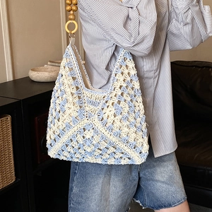 Dettaglio della borsa tote intrecciata a mano con motivi azzurri e manici in legno