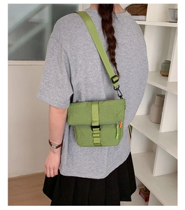 Détail du sac bandoulière à carreaux vert avec sangle réglable et poche zippée