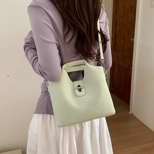 Détail du sac seau en cuir vert menthe avec fermoir rotatif argenté et poignée intégrée