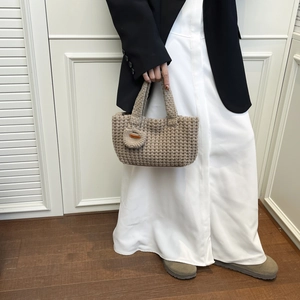 Detalle del bolso tote de punto beige hecho a mano con patrón cuadrado y adorno