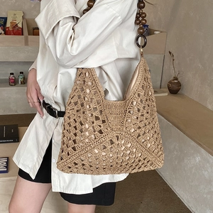 Dettaglio della borsa in paglia intrecciata con tracolla in perline di legno vintage