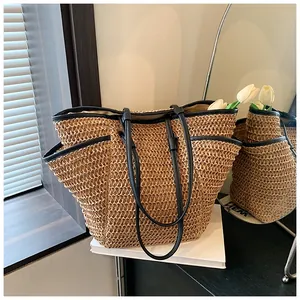 Détail du grand sac cabas en paille beige avec bordure en cuir noir et poches