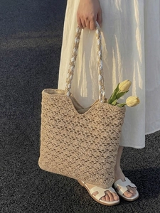 Woven straw tote bag with scalloped texture and two-tone rope handles for summer