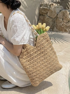 Beige hollow crochet tote bag with fan patterns on a white lace dress summer background
