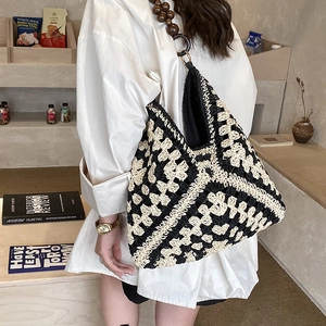 Dettaglio della borsa tote tessuta con motivi geometrici e manici in perline di legno