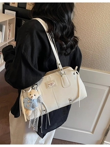 Retro cream white faux leather shoulder bag with bear pendant shown from side view