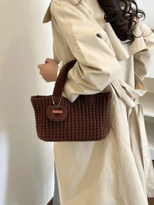 Bolso tote de punto marrón oscuro hecho a mano con colgante circular llevado por una modelo