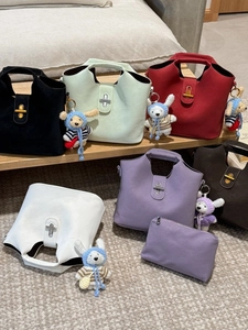 Lot de sacs seaux rétro multicolores avec breloques d'ours présentés sur un banc en bois