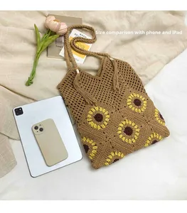 Detail of sunflower crochet tote bag showing large capacity with phone and tablet for scale