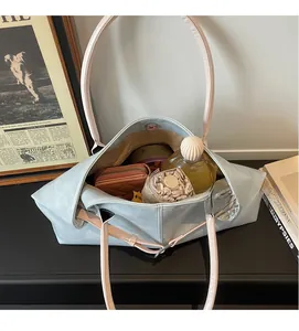 Intérieur spacieux d'un sac cabas bleu clair avec objets du quotidien comme un parapluie