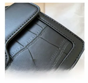 Détails des coutures soignées sur un sac en similicuir noir à motif crocodile