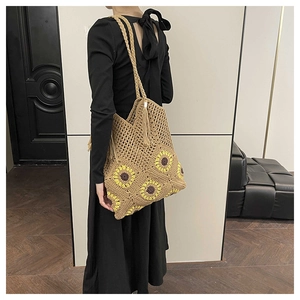 Detail of sunflower crochet tote bag with tassels shown on a model's shoulder