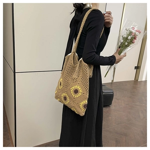 Detail of sunflower crochet tote bag with woven straps and bohemian fringe decoration