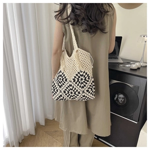 Detail of handmade crochet sunflower tote bag showing black and white geometric floral patterns