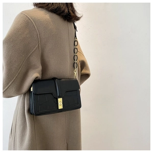 Détail du petit sac noir embossé crocodile avec fermoir doré et bandoulière chaîne