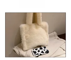 Size comparison of beige faux fur tote bag showing plush texture next to a smartphone