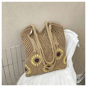 Detail of woven tote bag with sunflower crochet pattern and braided handle with tassel