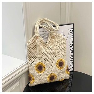 Detail of hand-crocheted tote bag with sunflower pattern and fringe tassels